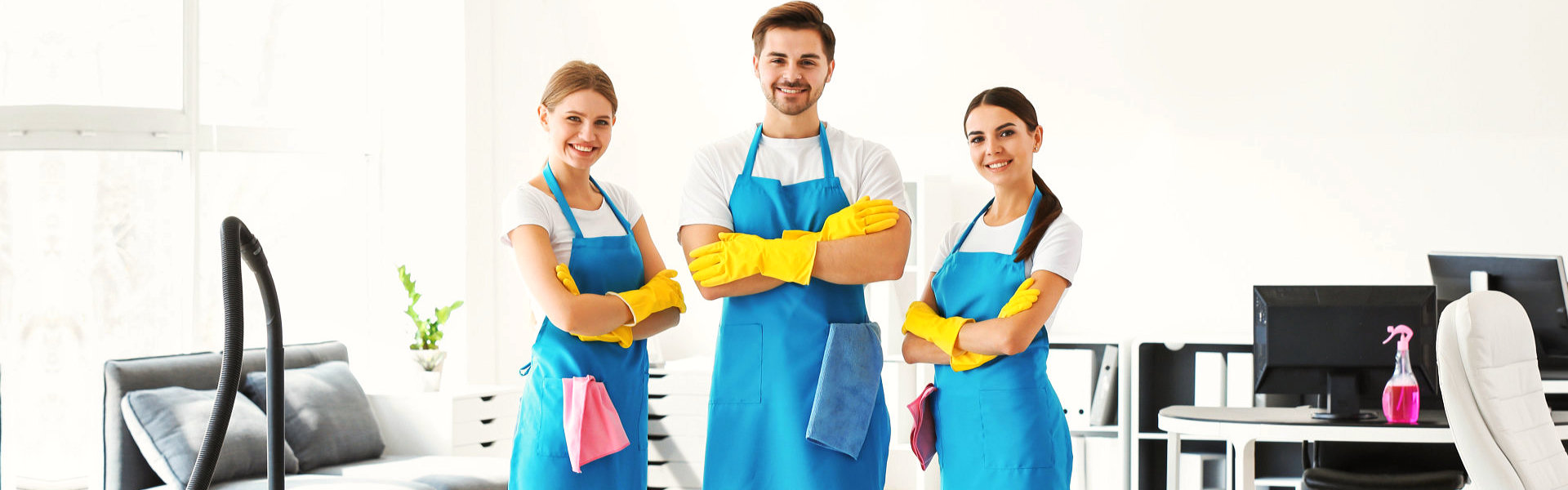 Three persons in blue aprons are positioned in a room